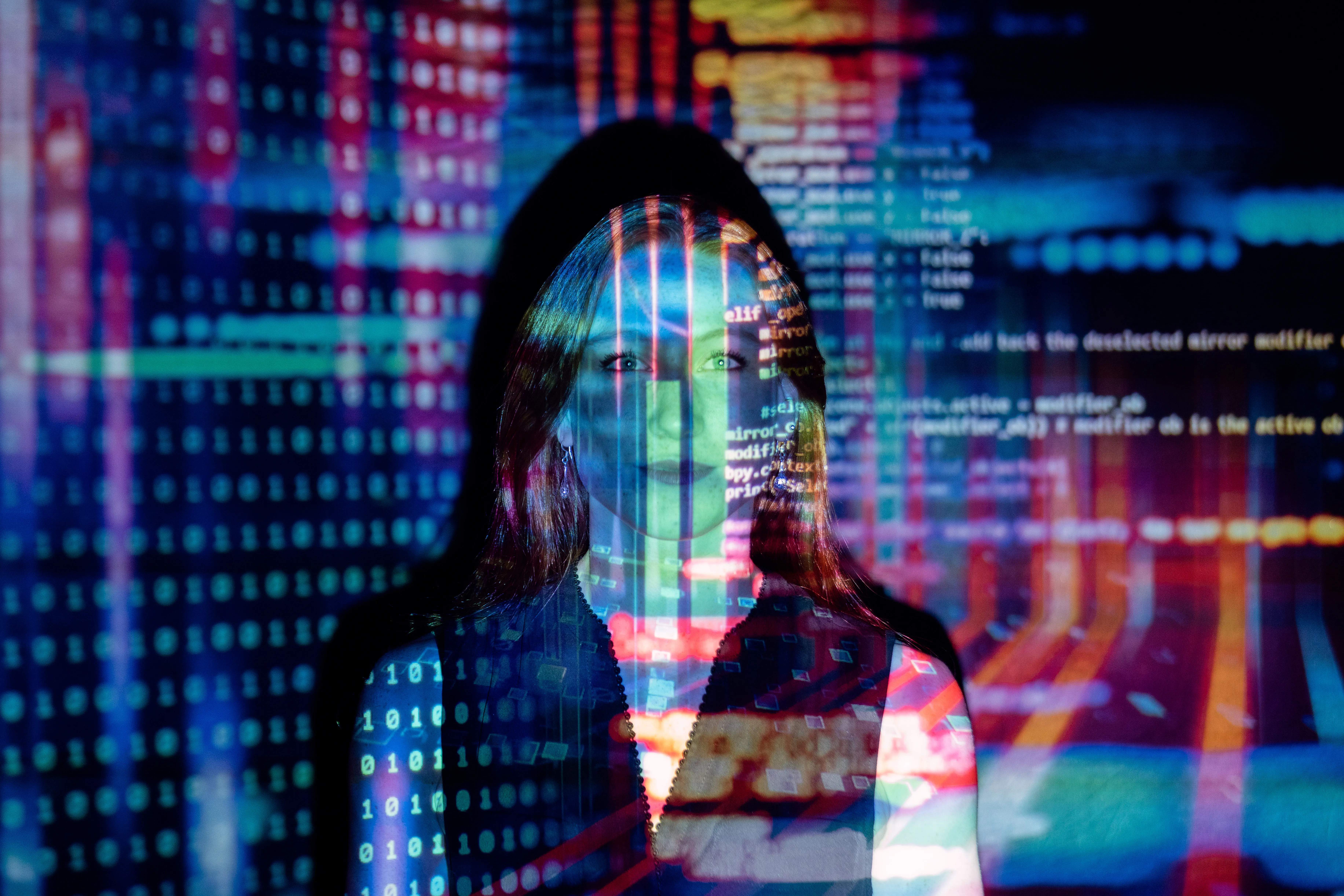 A photo of computer code projected on the face of a woman